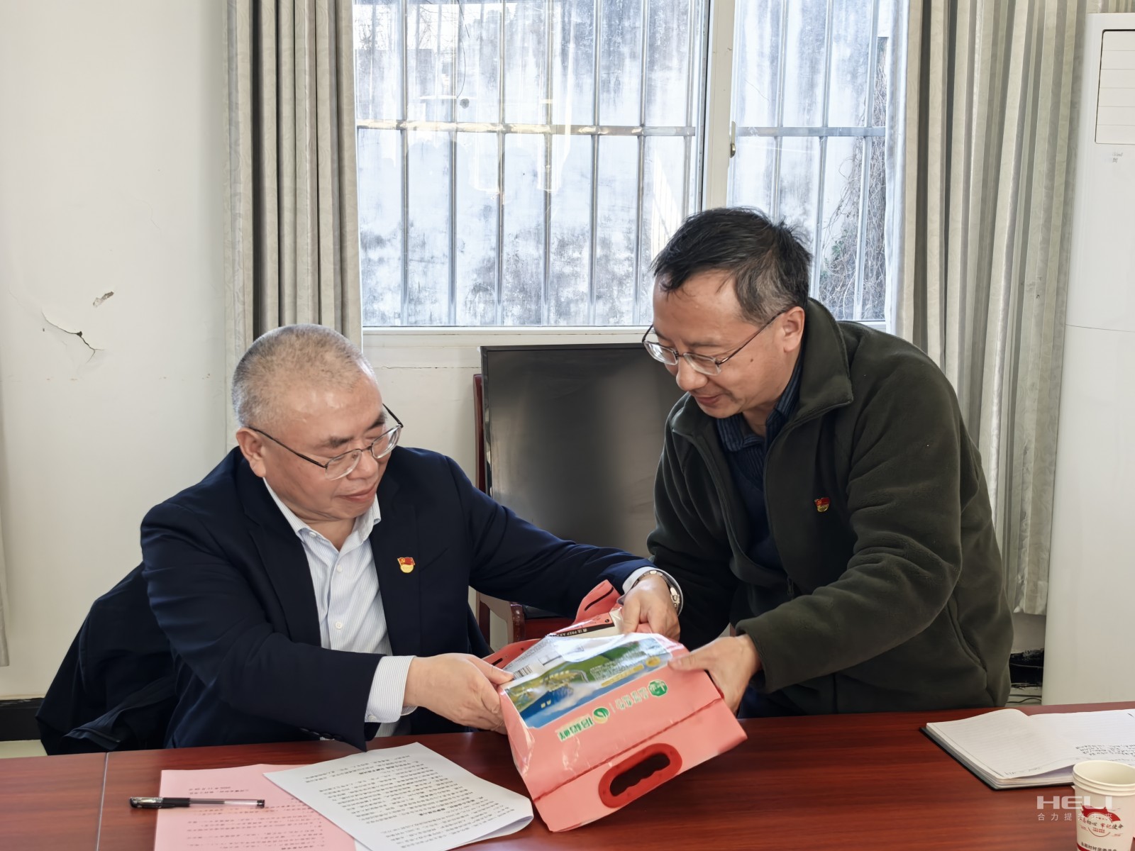 杨安国听取驻村干部介绍消费帮扶生态稻米.jpg